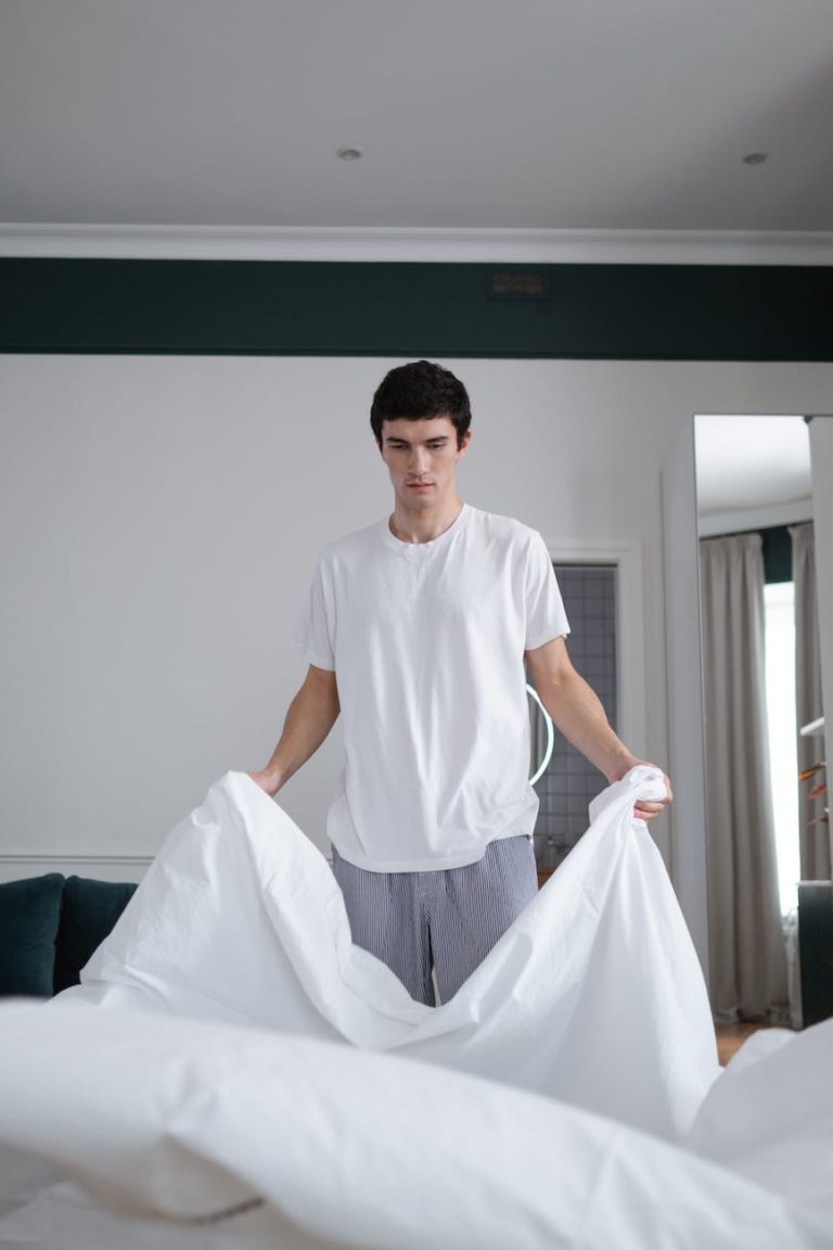 man in white shirt folding a blanket